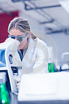 Science student looking through microscope in the lab