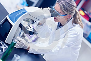 Science student looking through microscope in the lab