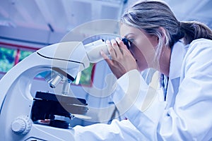 Science student looking through microscope in the lab