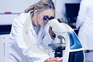 Science student looking through microscope in the lab