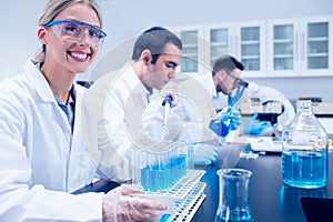 Science student using pipette in the lab to fill test tubes