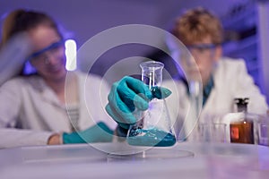 Science students doing chemical experiment in the laboratory at university, close-up.