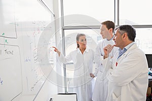 Science students and lecturer looking at whiteboard