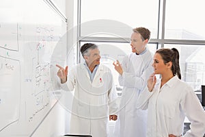 Science students and lecturer looking at whiteboard