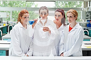 Science students pouring liquid in a flask