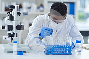 Science, test tubes and black man in laboratory, research and experiment with medical equipment. African person