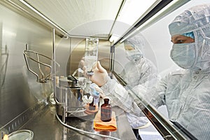 science workers in protective uniform at laboratory research work