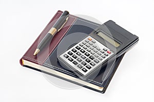 Scientific calculator and golden pen on business notebook