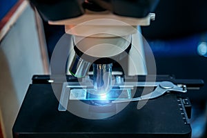 Scientific or medical test sample under light microscope in laboratory, close up