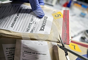 Scientific police opens with scissors a bag of evidence of a crime in scientific laboratory