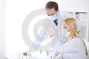 Scientific research team with clear solution in laboratory