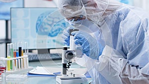 Scientific researcher doctor analyzing sample with blood using medical microscope