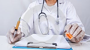 Scientific researcher or doctor using syringe and vaccine in a laboratory with white background. A doctor Filling vaccine to