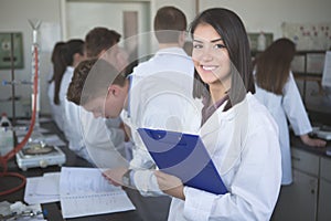 Scientific researcher holding a folder of chemical experiment research. Science students working with chemicals in the lab at the