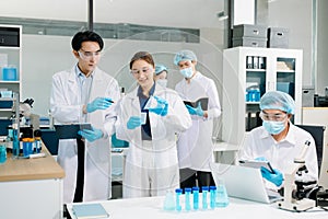 A scientific team working together in a modern laboratory, testing samples, mixing liquids, analyzing data, and using advanced lab