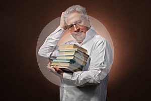 Scientific thinker, philosophy, elderly gray-haired man in a white shirt with a books, with studio light