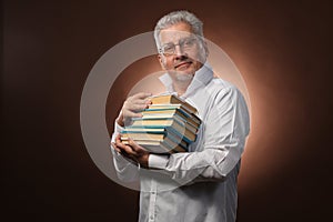 Scientific thinker, philosophy, elderly gray-haired man in a white shirt with a books, with studio light