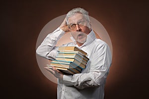 Scientific thinker, philosophy, elderly gray-haired man in a white shirt with a books, with studio light