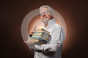 Scientific thinker, philosophy, elderly gray-haired man in a white shirt with a books, with studio light