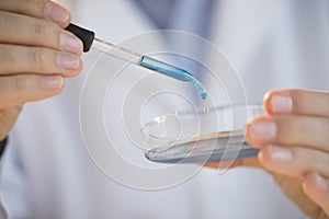 Scientist Adding Chemical Into Petri Dish