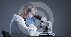 Scientist analyzing samples under the microscope