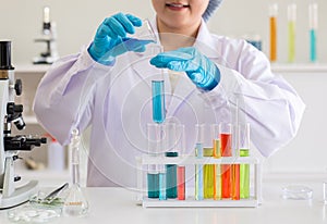 Scientist asian woman working putting medical chemicals sample in test tube at laboratory