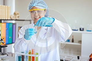 Scientist asian woman working putting medical chemicals sample in test tube at laboratory