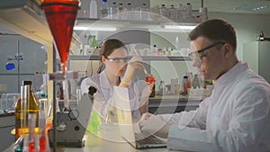 Scientist with assistant working in laboratory in the evening.