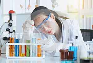 Scientist beautiful woman working and putting medical chemicals sample in test tube at lab office,Close up photo