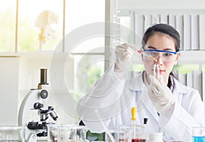 Scientist beautiful woman research and drop medical chemicals sample in test tube at lab