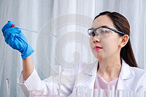 Scientist beautiful woman research and drop medical chemicals sample in test tube at laboratory, Science, chemistry, technology,
