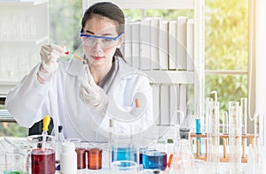 Scientist beautiful woman working putting medical chemicals sample in test tube at laboratory