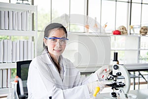 Scientist beautiful women working putting medical chemicals sample on microscope at laboratory,Close up