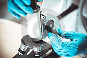 Scientist biochemist or microbiologist working research with a microscope in laboratory. For protect outbreak Coronavirus Covid19