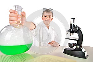 Scientist boy holds in his hand a big flask with green foaming liquid incide