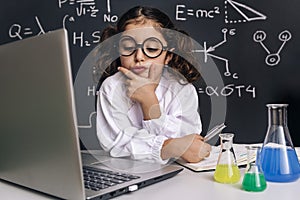Scientist child looking pensive to the computer