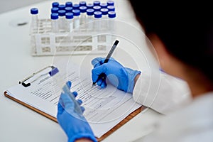 Scientist, clipboard and lab results with test tube, medic and microbiologist or research for vaccine study. Female