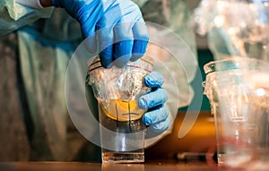 A scientist closes a yolk in a cup.