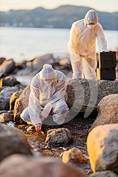Scientist collecting water sample at the seashore