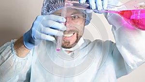 Scientist doctor in medical uniform, holding flask and watching the progress of experiment