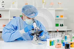 Scientist Doctor in research lab working observer dangerous virus with microscope photo