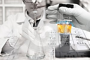 Scientist is doing the experiment, the titration of the reagent in the flask, tube in scientist hand