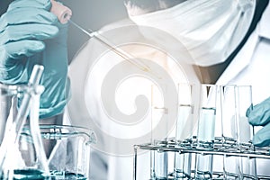 Scientist dropping chemical liquid to flask in lab Glass laborat