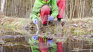 Scientist ecologist in the forest taking samples of water photo