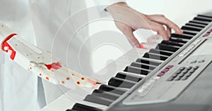 Scientist engineer is tasting robotic prosthesis hand playing the piano. Playing two hands, a robotic prosthetic hand