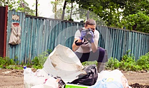 Scientist environmentalist making photos of garbage dump.