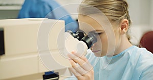 Scientist examining bacteria under microscope at laboratory