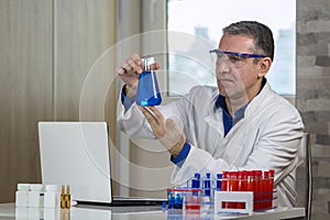 Scientist Examining a Beaker of Blue Fluid in Biochemistry Lab