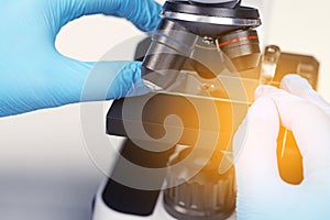 Scientist examining sample on slide under microscope, closeup