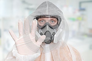 Scientist with FFP3 respirator mask is showing STOP gesture